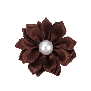 Gros plan d'une fleur faite main en ruban de satin marron foncé avec une perle blanche centrale