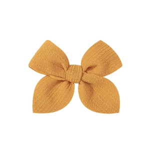 Detailed macro view of 3.5-inch bright yellow handmade fabric hair bow with textured fabric
