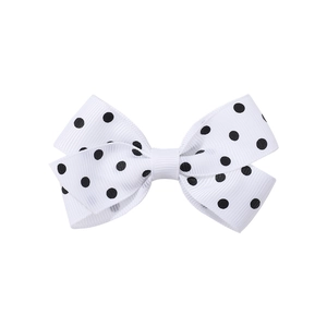Dettaglio del fiocco per capelli a pois bianchi con trama in nastro e cuciture precise
