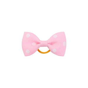 Detail of pink polka dot ribbon bow hair tie showing ribbed texture and elastic band