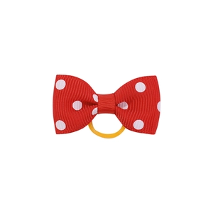 Détail d'un nœud papillon rouge à pois avec un élastique jaune haute élasticité pour cheveux