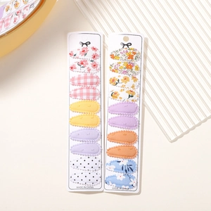 Detail view of 20-piece floral and polka dot fabric covered hair clips on display cards