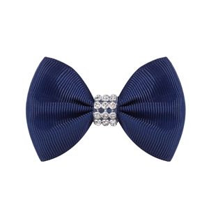 Détail d'un nœud papillon bleu marine en gros-grain avec strass brillants au centre
