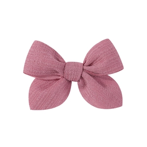 Detail of a 3.5 inch dusty rose pink bow hair clip made of ribbed textured fabric