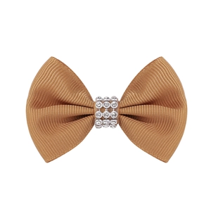 Détail d'un nœud à cheveux en ruban gros-grain champagne avec centre en strass brillant