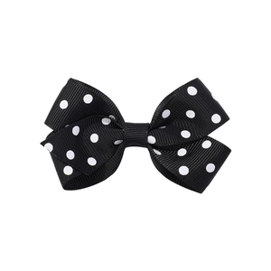 Dettaglio del fiocco per capelli in grosgrain nero a pois bianchi per bambine