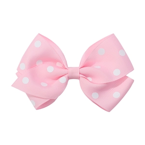 Dettaglio del fiocco per capelli in nastro grosgrain rosa con pois bianchi e trama