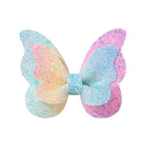 Gros plan sur une pince papillon faite main avec des paillettes dégradées couleur macaron
