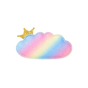 Detail view of a glittery rainbow cloud hair clip with a tiny golden crown on top
