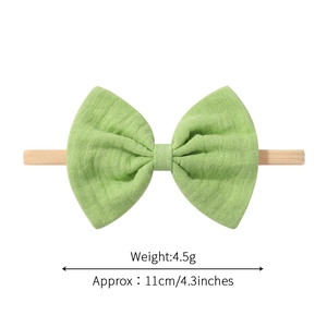 Elastisches Baby-Stirnband mit hellgrüner Baumwollschleife und hautfarbenem Nylonband