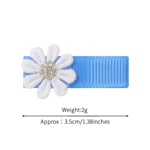 Dettaglio molletta azzurra con margherita ricamata bianca, lunghezza 3,5 cm e peso 2 g