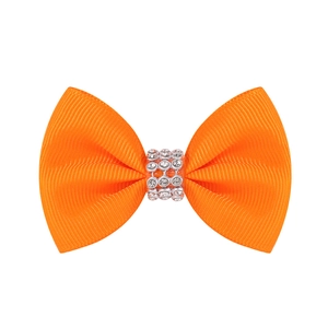 Détail d'un nœud en ruban gros-grain orange avec strass brillants sur pince en métal