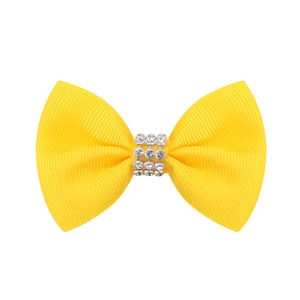 Détail d'un nœud en ruban gros-grain jaune vif avec centre en strass étincelants