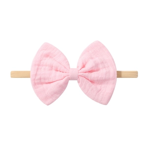 Detailaufnahme von Baby-Stirnband aus Nylon mit hellrosa Musselin-Schleife und weichem Stoff