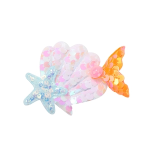 Détail d'une barrette sirène à paillettes avec coquillage et étoile de mer pour filles