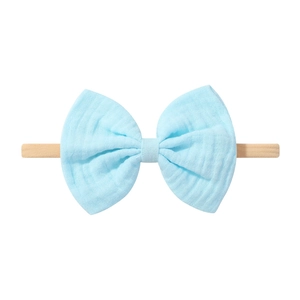 Détail du nœud en gaze bleu clair sur un bandeau élastique en nylon pour bébé