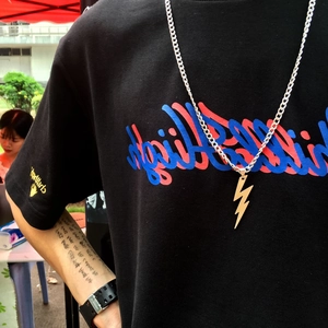 Gros plan d'un pendentif éclair en argent avec une grosse chaîne à maillons cubains