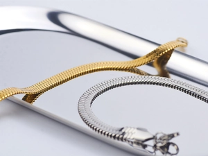 Macro della catena piatta a serpente in oro e argento con riflessi metallici lucidi