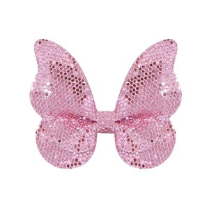 Détail de la barrette papillon à paillettes roses montrant la texture scintillante