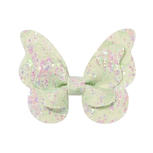 Détail d'une pince à cheveux papillon vert menthe avec paillettes et dentelle