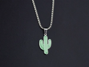 Detail of green enamel cactus pendant with silver box chain on black background