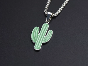 Macro shot of a silver cactus pendant with green enamel detail and a round box chain