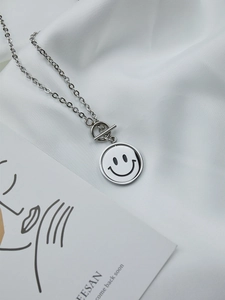 Detail of silver smiley face necklace with rotating pendant and secure OT toggle clasp