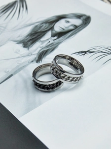 Detail of two stainless steel spinning chain rings with polished silver and black finishes