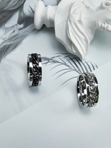 Close-up of rotatable Cuban chain rings in silver and black industrial steel style