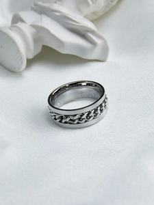 Detailed close-up of a silver spinner ring featuring a rotatable Cuban chain on polished steel