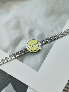 Detalle de la pulsera de cadena de acero inoxidable con colgante de cara sonriente