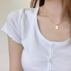 Collier minimaliste en acier inoxydable doré avec pendentif Lucky 7 sur un modèle