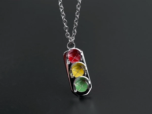 Vue macro du pendentif de feu tricolore hip-hop en acier inoxydable sur fond noir mat