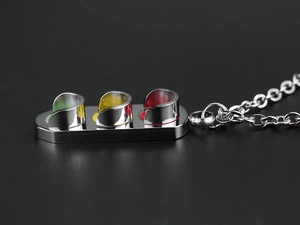 Vue macro du pendentif de feu tricolore hip-hop avec émail rouge jaune vert sur acier