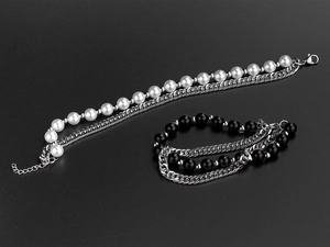 Detail of adjustable double-layer titanium bracelet with white pearls and black beads