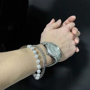 Close-up of hip-hop silver jewelry set with crystal watch and pearl cuban bracelets
