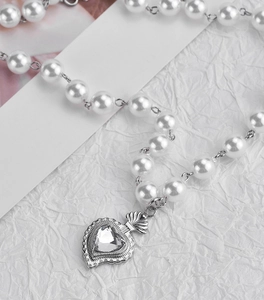 Elegant pearl necklace featuring a silver heart-shaped crown pendant with zircon gemstone