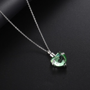 Detalle de collar de urna corazón con cristal verde y grabado conmemorativo único