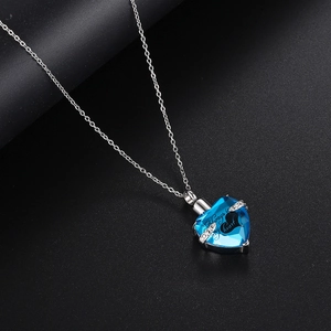 Detalle del colgante de corazón con cristal azul y grabado Always in my heart en acero