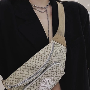 Detail showing the NY monogram crossbody bag with dual zippers and adjustable canvas strap