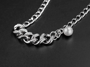 Vue détaillée du collier gourmette argenté orné de cristaux brillants et d'une perle blanche