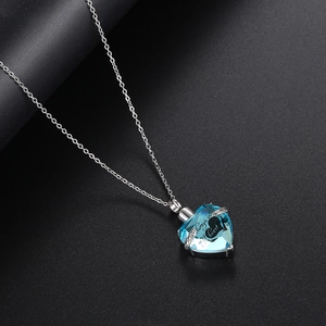 Detalle del collar de urna de cristal azul en forma de corazón con grabado Always in my heart