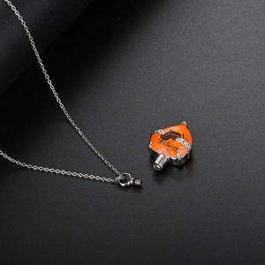 Detalle de colgante de corazón naranja con grabado Always in my heart para cenizas