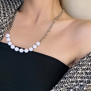 Asymmetric reflective pearl and titanium steel chain necklace worn by a fashion model