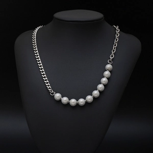 Asymmetric necklace featuring silver Cuban link chain and large white pearls on black model