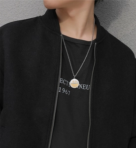 Détail macro du collier hip-hop argenté avec pendentif visage souriant doré style urbain