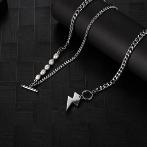 Detail of a punk style silver chain necklace with freshwater pearls and lightning bolt charm