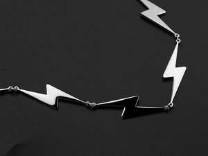 Detail shot of polished stainless steel lightning bolt chain with a sleek mirror finish