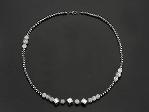 Detail of hip hop beaded necklace with stainless steel beads and silver dice pendants