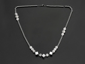 Detailed close-up of hip-hop necklace with silver beads, faux pearls and dice charms